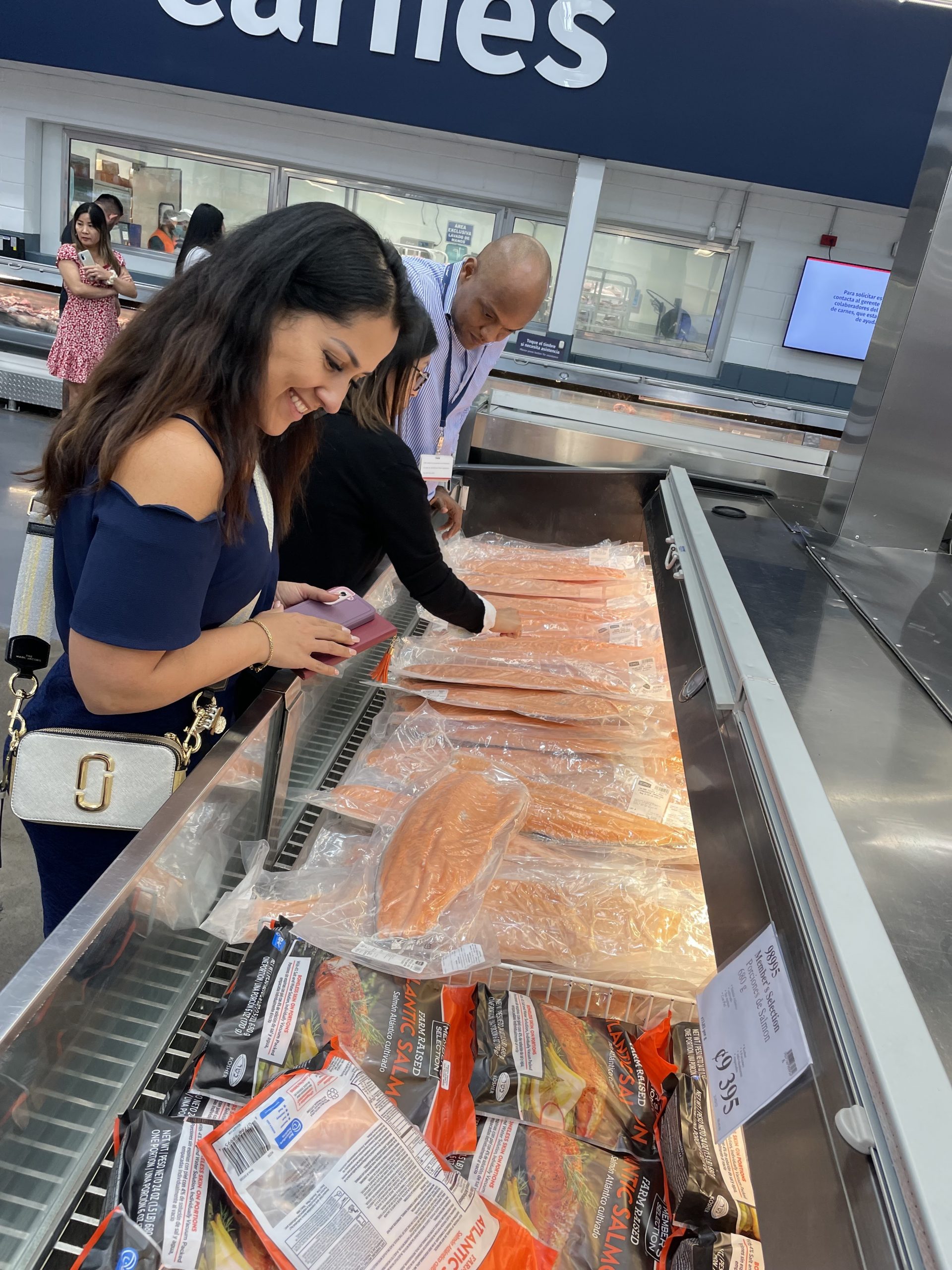 Woman looking at frozen fish from a PriceSmart store