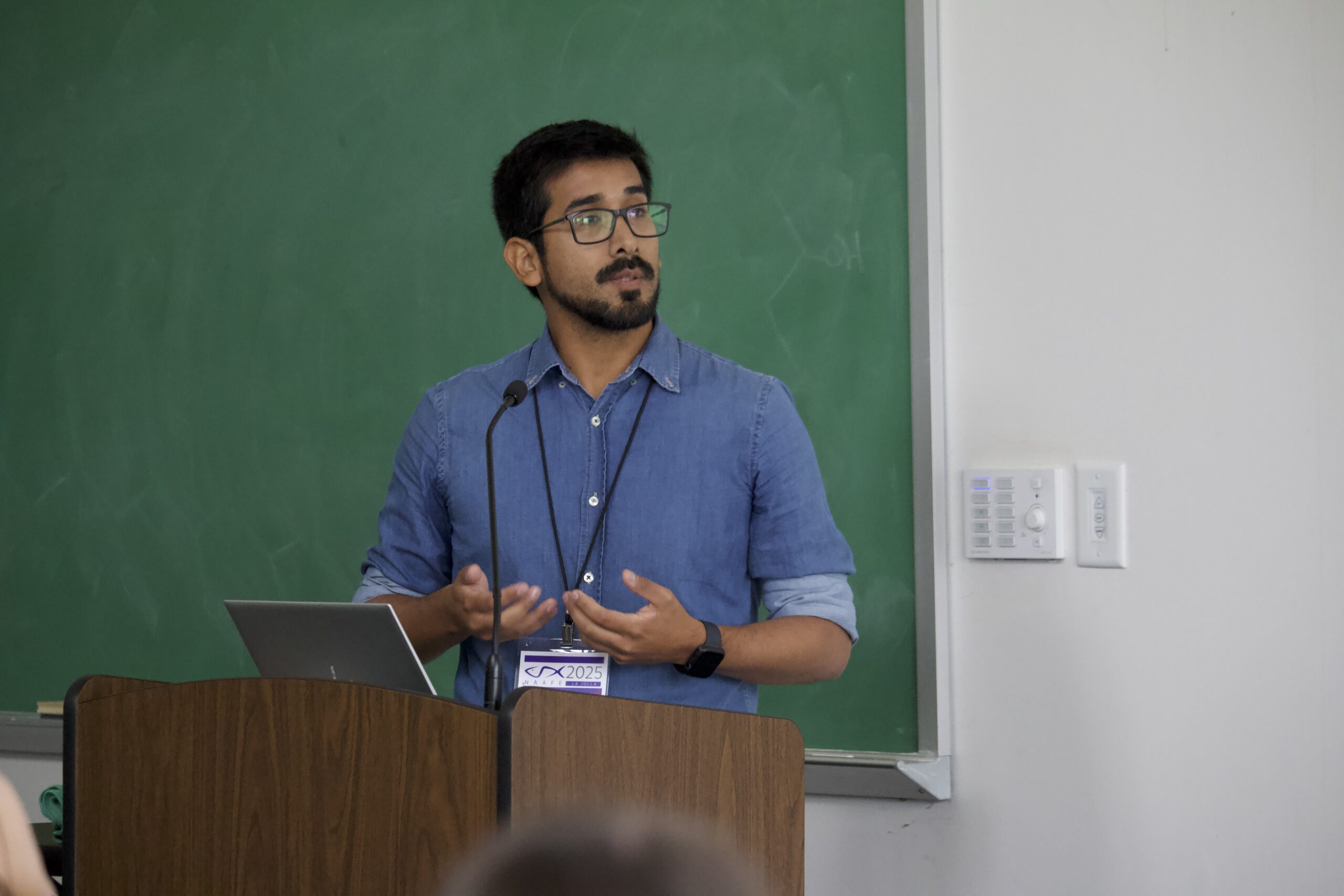 Presenter speaks behind a podium in Vaughn Hall.